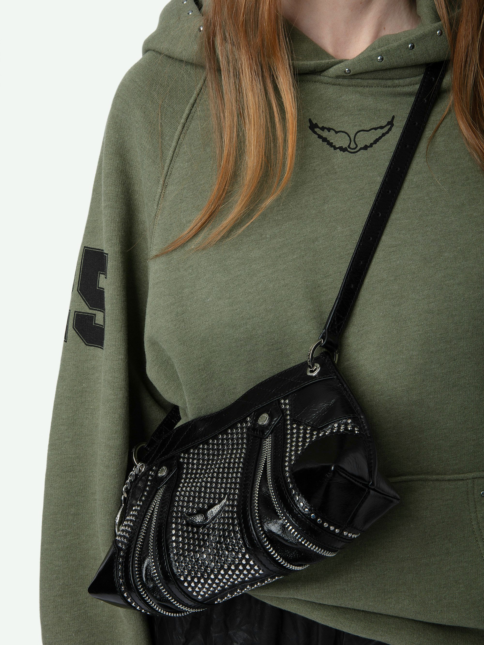 Sudadera Georgy - Sudadera de felpa de color caqui con capucha y bolsillo decorado con tachuelas, estampado de alas en la parte delantera e insignias.